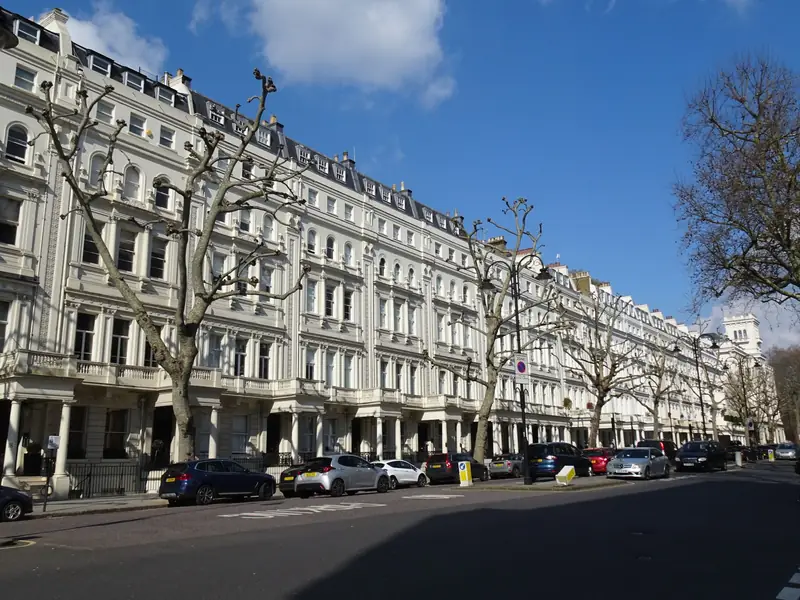 Terrace of white stucco London townhouses with dormer windows in the mansard roof storey