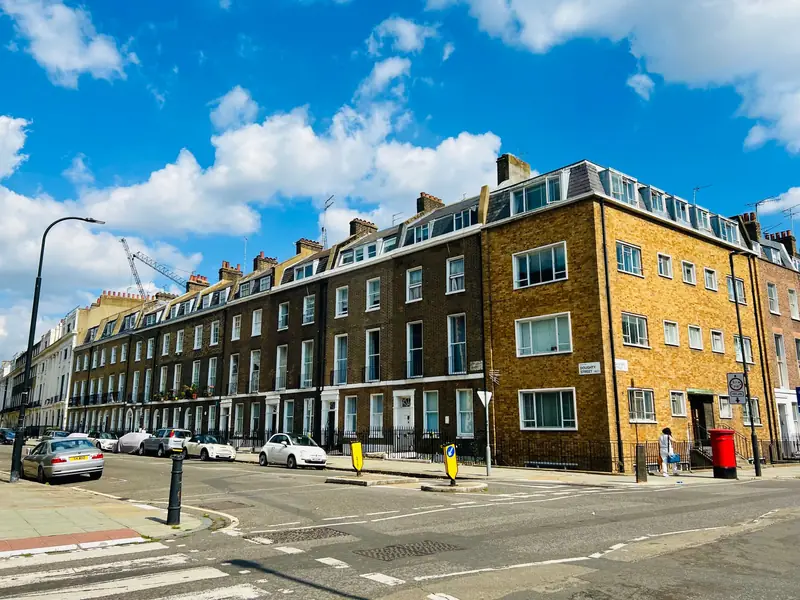 Brick apartment building on a sunny London street corner