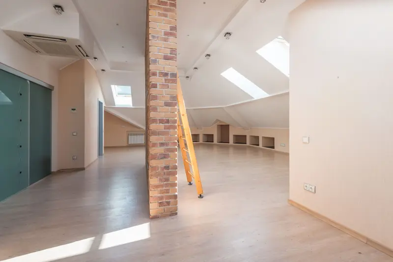 Converted attic room with roof windows, timber floor and an exposed brick chimney breast