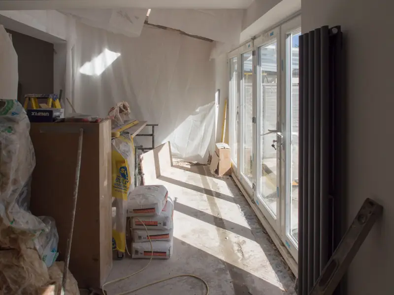 Room being renovated, with new glazed doors and bare plastered walls