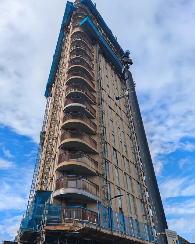 Tall London building in scaffolding with a crane on top